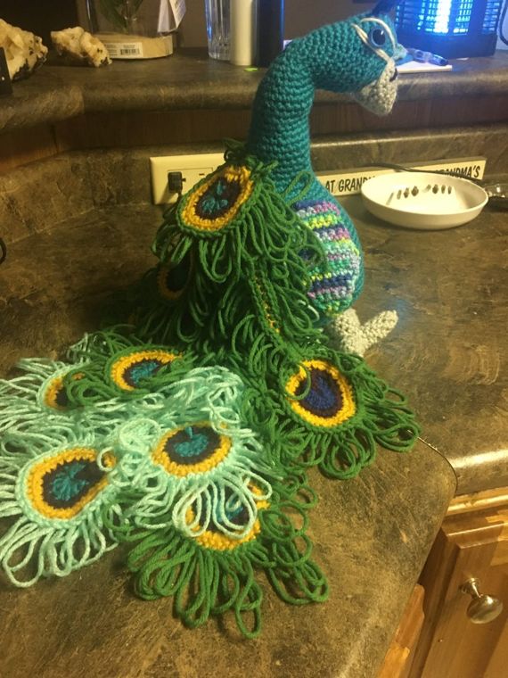Peacock, Full Plume: A teal peacock with a long looped train in greens and aqua.